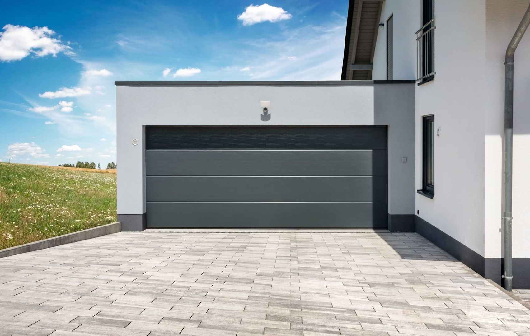 Graue Garagentür an einer weißen Wand, die einen klaren und minimalistischen Stil zeigt